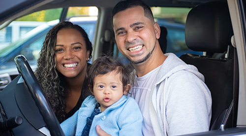 Smiling family of three inside the car photo